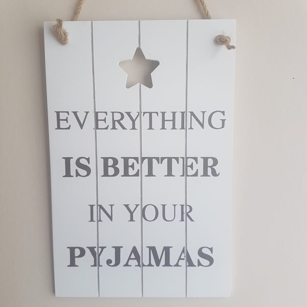 white slatted wooden sign with 'Everything is better in your pyjamas' quote and cut out star shape