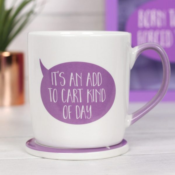 A white mug with a purple handle and speech bubble saying 'It's an Add to Cart kind of day' With a coaster decorated with shopping bags and hangers