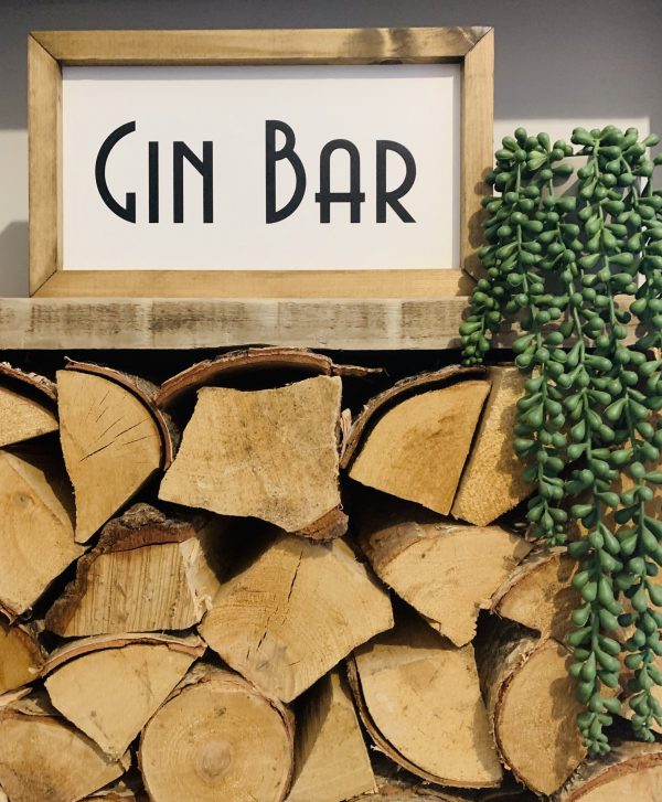Handmade rustic sign with off white background and black font 'Gin Bar'