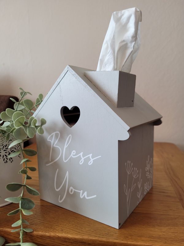 This gorgeous house shaped tissue box is a must for any home. Painted grey with white writing 'Bless You' and floral detail on the sides. To fit standard cube shaped tissue boxes.