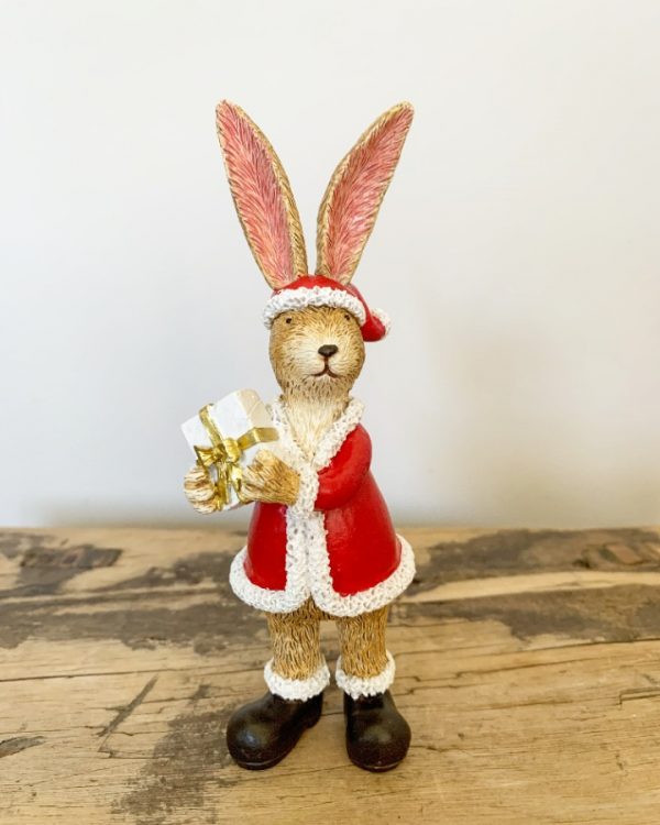 A wonderfully detailed standing rabbit decoration, complete with Santa outfit and a gift wrapped in ribbon.